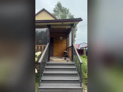 Лестница с коваными перилами у деревянного дома — дачное крыльцо из металла, наша работа